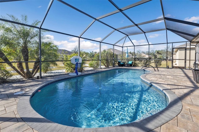 view of swimming pool with glass enclosure and a patio