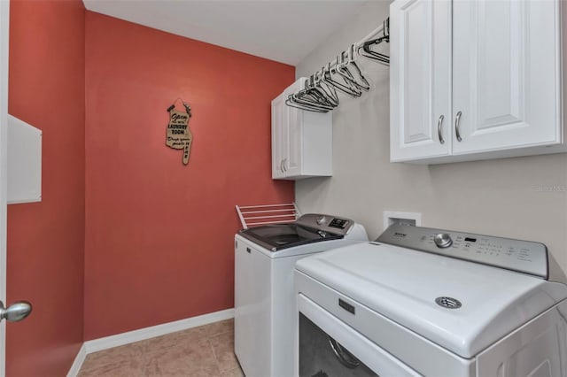 laundry room featuring light tile patterned floors, washer and dryer, and cabinets