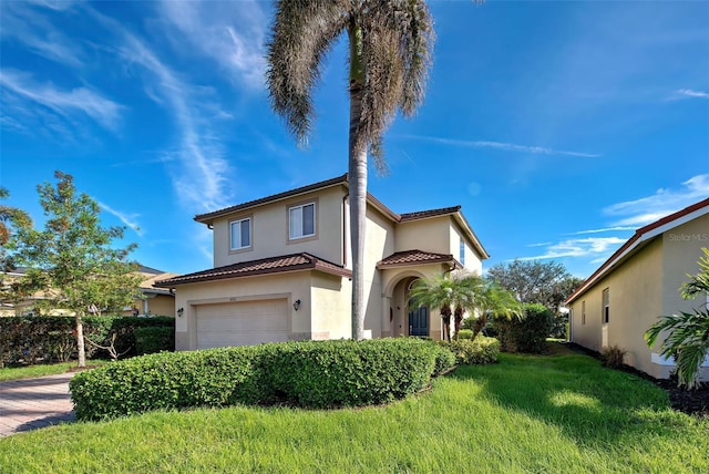 mediterranean / spanish house with a garage and a front yard