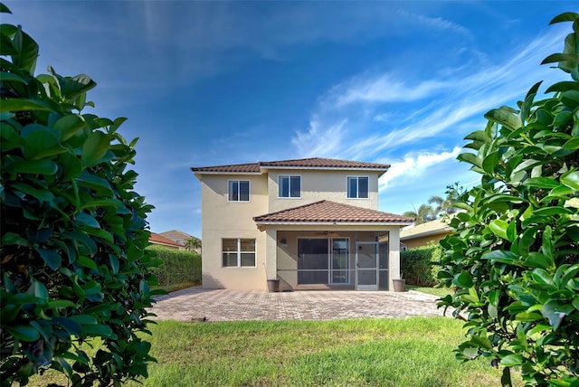 back of house featuring a sunroom, a yard, and a patio