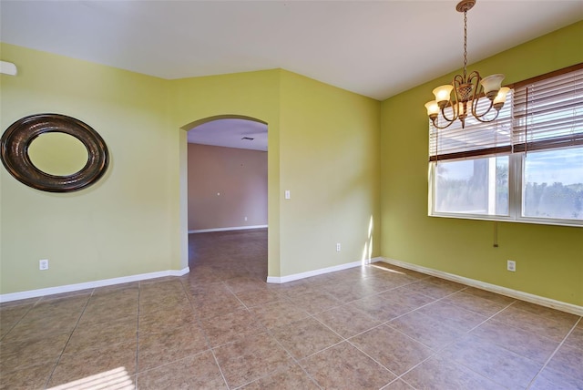 tiled empty room with an inviting chandelier