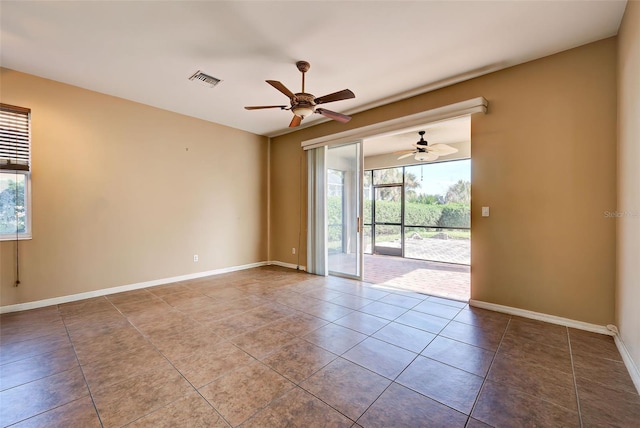 tiled empty room with ceiling fan and a healthy amount of sunlight