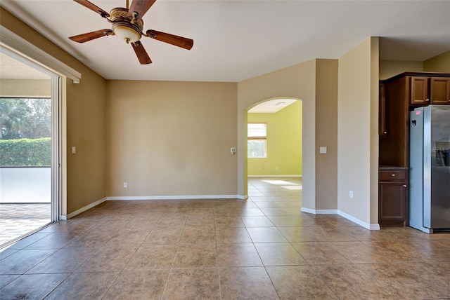 spare room with ceiling fan and light tile patterned floors