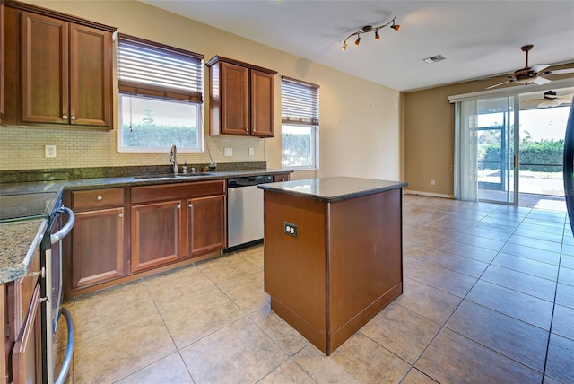 kitchen with sink, ceiling fan, light tile patterned floors, appliances with stainless steel finishes, and a kitchen island