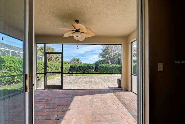 unfurnished sunroom with ceiling fan