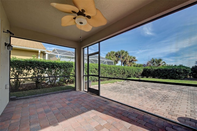 unfurnished sunroom with ceiling fan