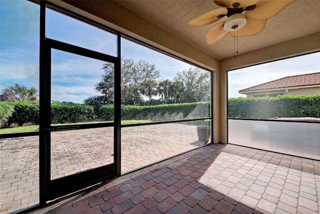 unfurnished sunroom featuring ceiling fan