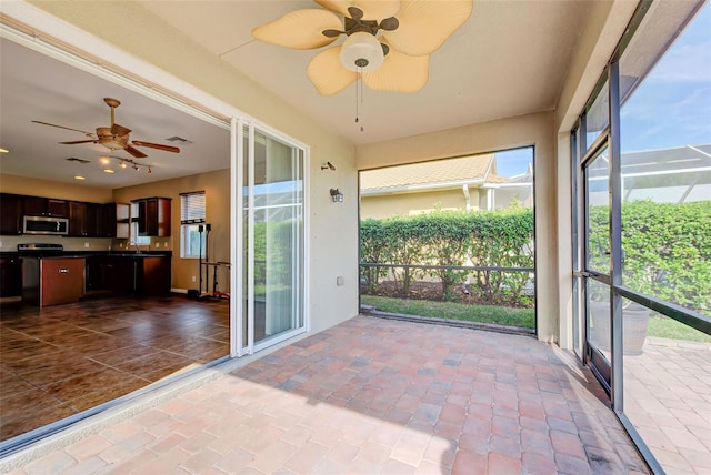 unfurnished sunroom with ceiling fan