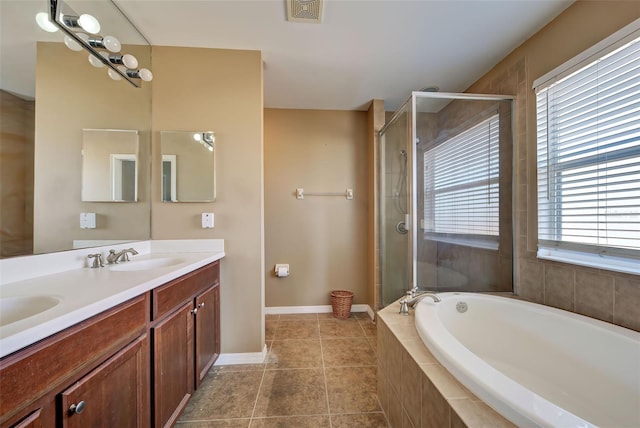 bathroom with vanity, tile patterned flooring, and plus walk in shower