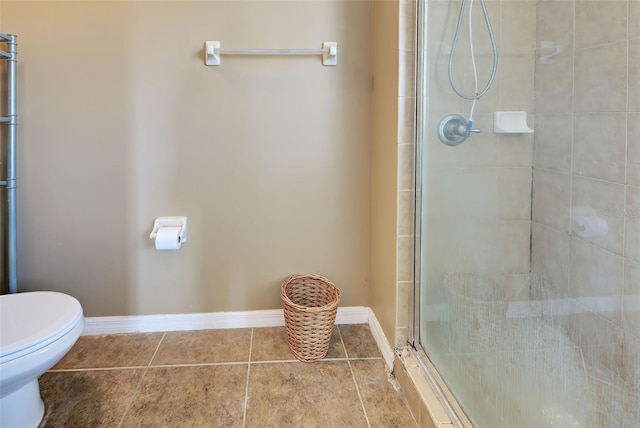 bathroom featuring tile patterned flooring, toilet, and a shower with shower door