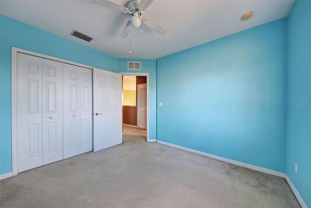 unfurnished bedroom with ceiling fan, a closet, and light carpet