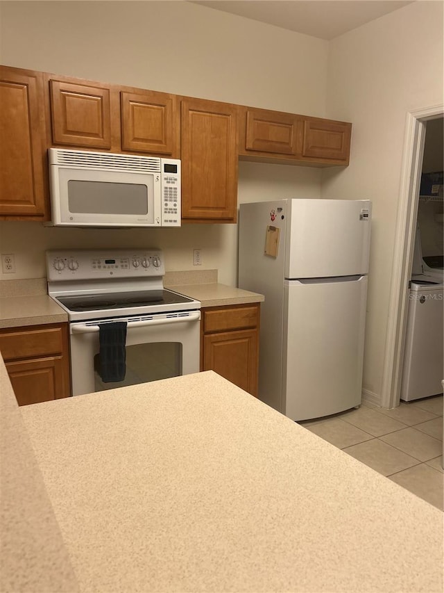 kitchen featuring light tile patterned flooring and white appliances