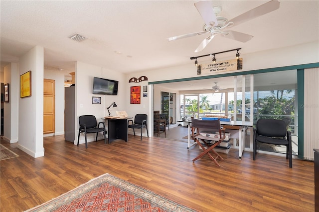 dining space with ceiling fan, track lighting, a textured ceiling, and hardwood / wood-style flooring