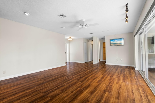 spare room with ceiling fan, dark hardwood / wood-style flooring, track lighting, and a textured ceiling