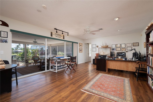 home office featuring ceiling fan, dark hardwood / wood-style flooring, and a textured ceiling