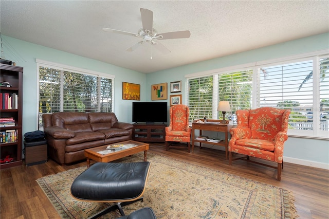 living room with dark hardwood / wood-style flooring, a textured ceiling, ceiling fan, and a healthy amount of sunlight