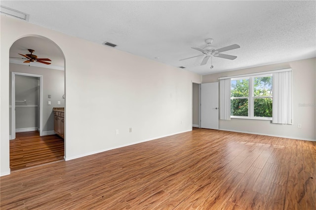 unfurnished room with hardwood / wood-style flooring, ceiling fan, and a textured ceiling