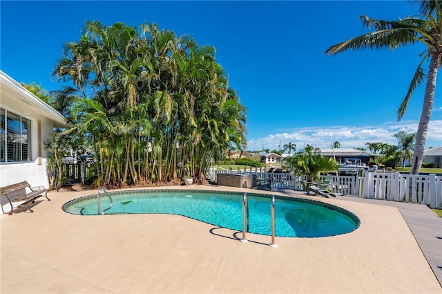 view of swimming pool with a patio and a hot tub