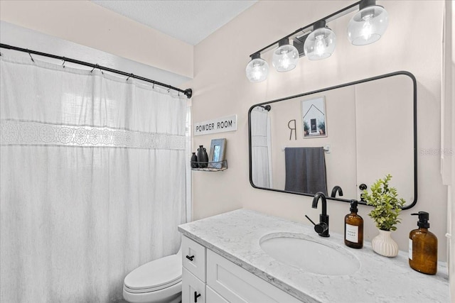 bathroom featuring vanity, a textured ceiling, and toilet