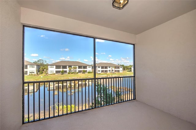 unfurnished sunroom featuring a water view