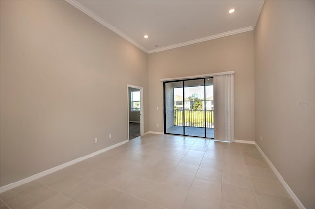 empty room with light tile patterned floors, ornamental molding, and a high ceiling