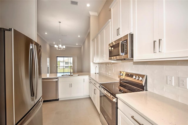 kitchen with white cabinets, hanging light fixtures, sink, decorative backsplash, and appliances with stainless steel finishes