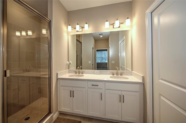 bathroom featuring tile patterned floors, vanity, and a shower with door