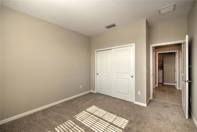 unfurnished bedroom with a closet and light colored carpet