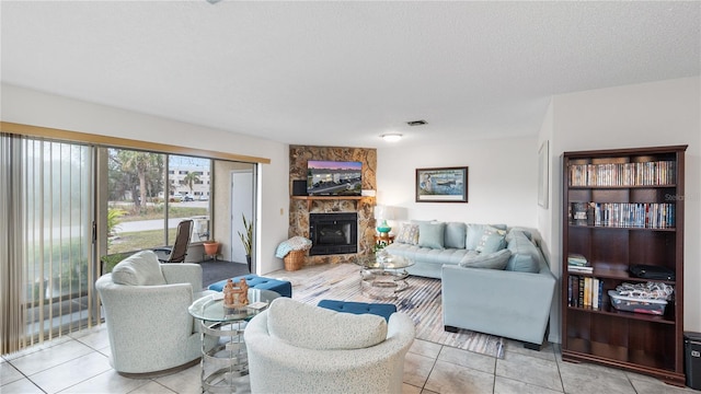 living room featuring a fireplace, light tile patterned floors, and a textured ceiling