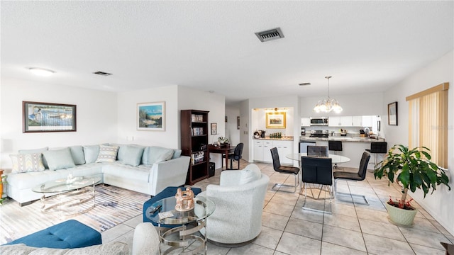 tiled living room featuring a textured ceiling and a notable chandelier