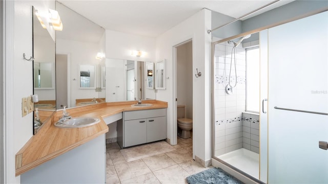 bathroom featuring tile patterned floors, vanity, an enclosed shower, and toilet