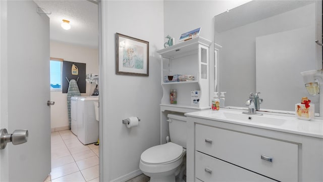 bathroom featuring tile patterned floors, a textured ceiling, vanity, washing machine and dryer, and toilet