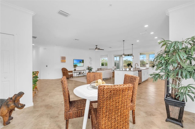 dining room featuring ceiling fan, sink, and crown molding