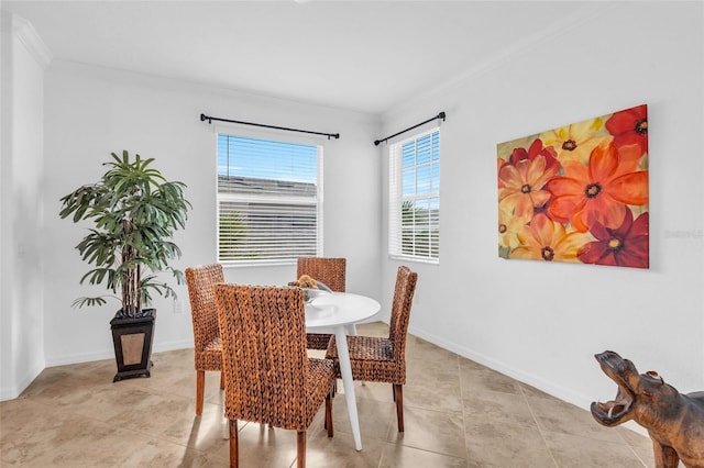 dining space with light tile patterned floors and crown molding