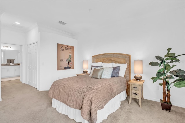 carpeted bedroom featuring ensuite bathroom and crown molding