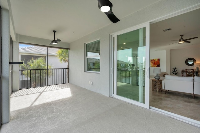 unfurnished sunroom featuring ceiling fan