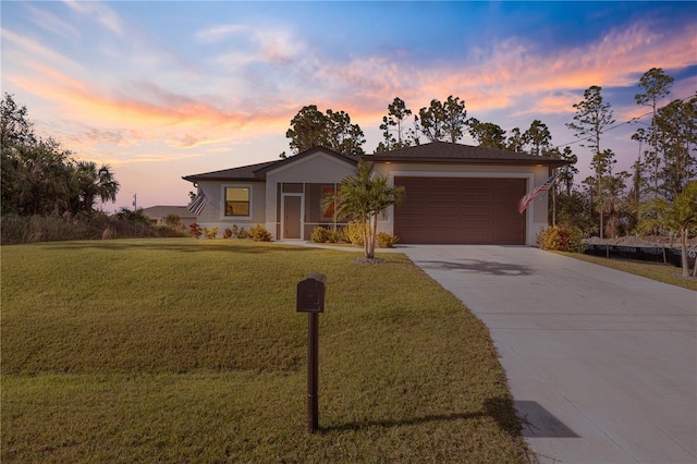 single story home featuring a garage and a yard