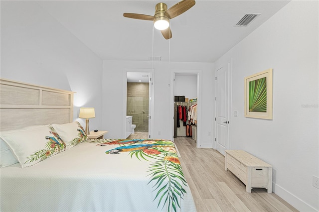 bedroom featuring ensuite bath, ceiling fan, a spacious closet, light hardwood / wood-style flooring, and a closet