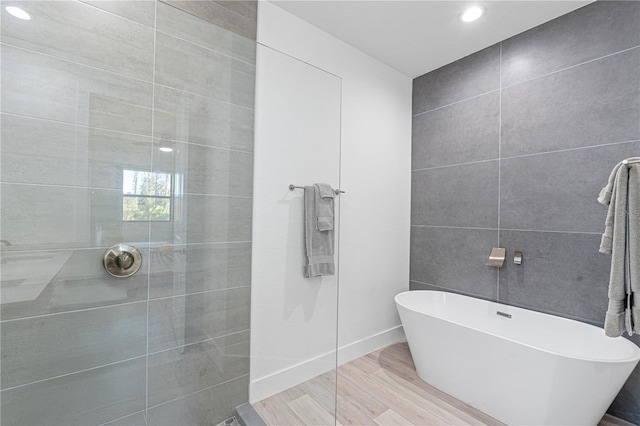 bathroom featuring hardwood / wood-style flooring and separate shower and tub