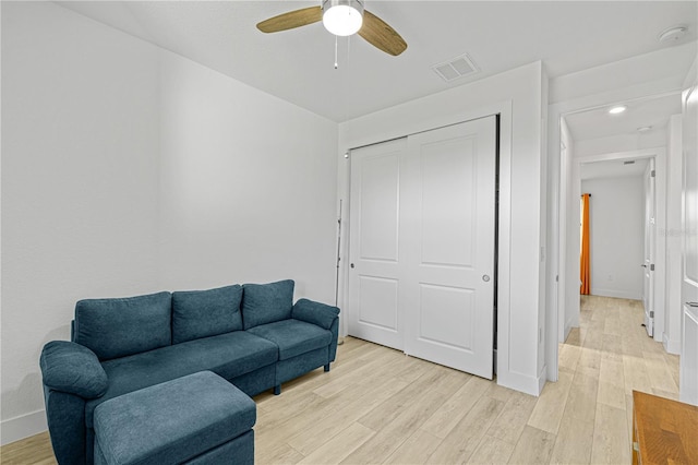 living room featuring ceiling fan and light hardwood / wood-style flooring