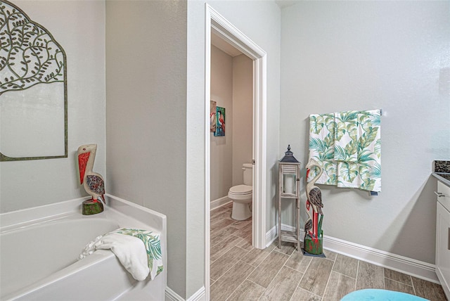 bathroom featuring a bathtub, toilet, and vanity