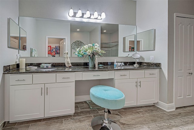 bathroom featuring vanity and a shower with shower door