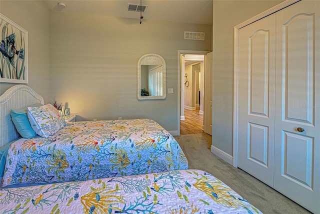 bedroom with light carpet and a closet