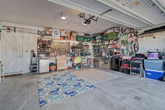 garage with a workshop area, a garage door opener, and fridge