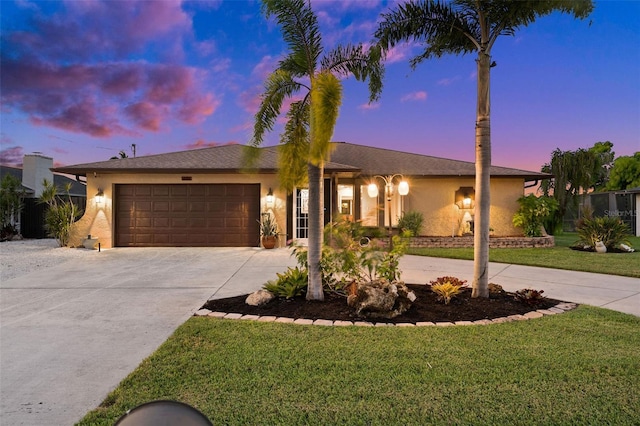 ranch-style home featuring a lawn and a garage