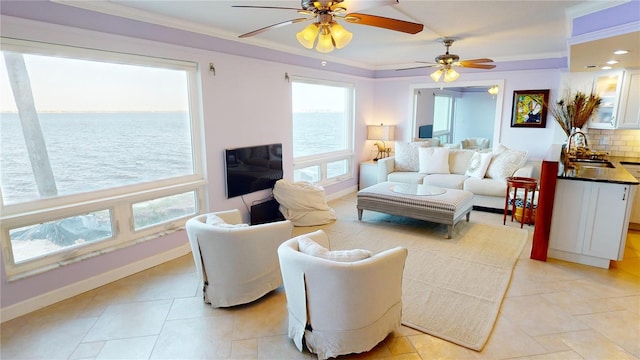 living room with crown molding, sink, and light tile patterned floors