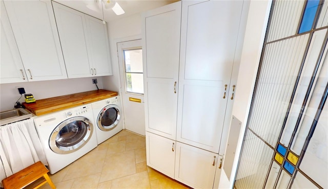 washroom featuring cabinets, independent washer and dryer, and light tile patterned flooring