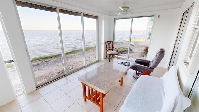 sunroom featuring a water view and ceiling fan