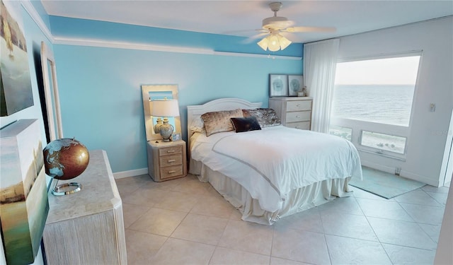 bedroom featuring ceiling fan, light tile patterned flooring, and a water view