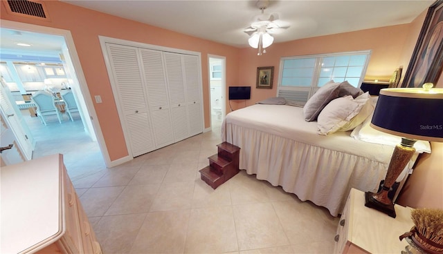 tiled bedroom featuring ceiling fan and a closet